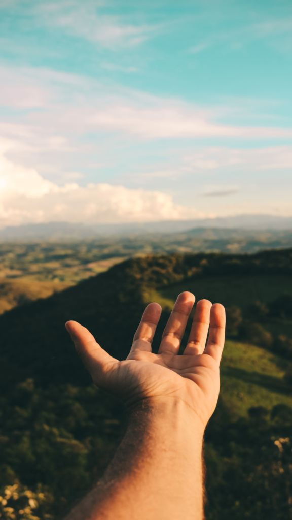 a hand pointing towards the mountains from the height