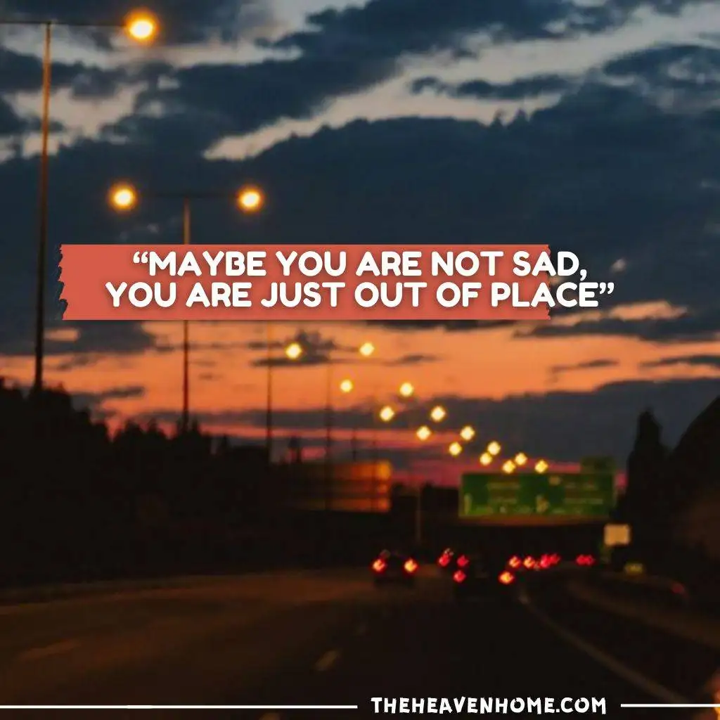 "Blurred highway during sunset with a motivational sad quote: 'Maybe you are not sad, you are just out of place.'"